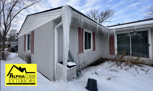 Ice dam forming on roof edge in Dayton, Ohio with large icicles causing potential winter roof damage