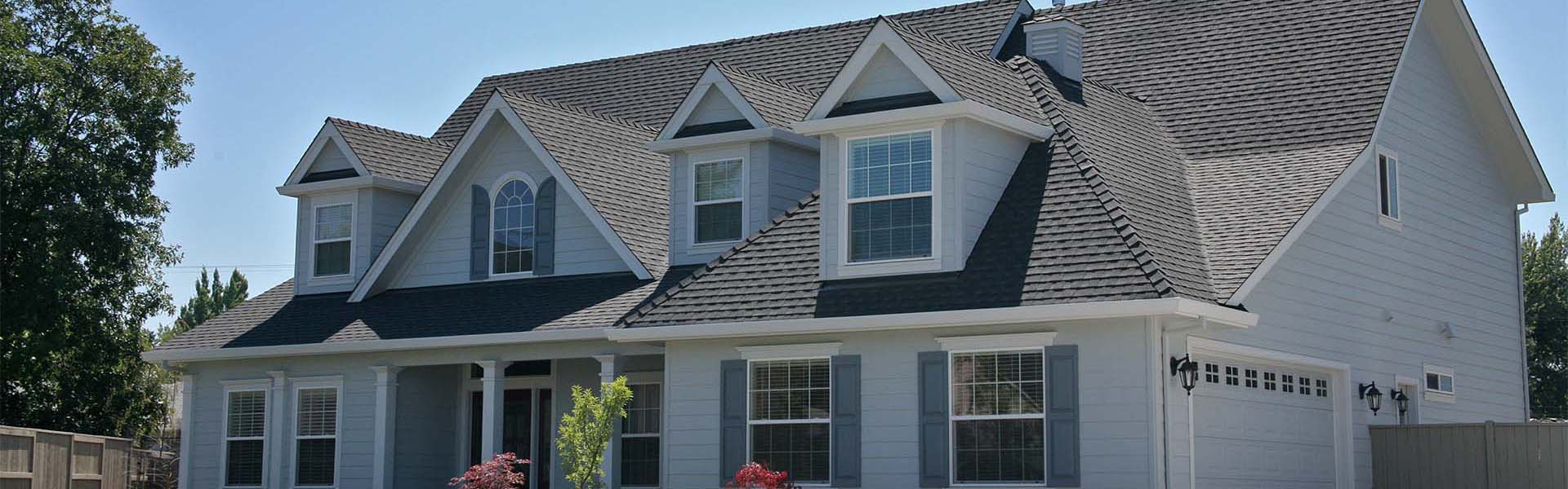 Two-story home with light blue siding, gabled dormers and a dark gray architectural asphalt shingle roof