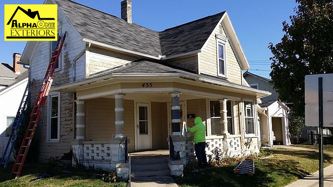 Exterior painting preparation on older Dayton Ohio home with ladder setup and siding prep work in progress