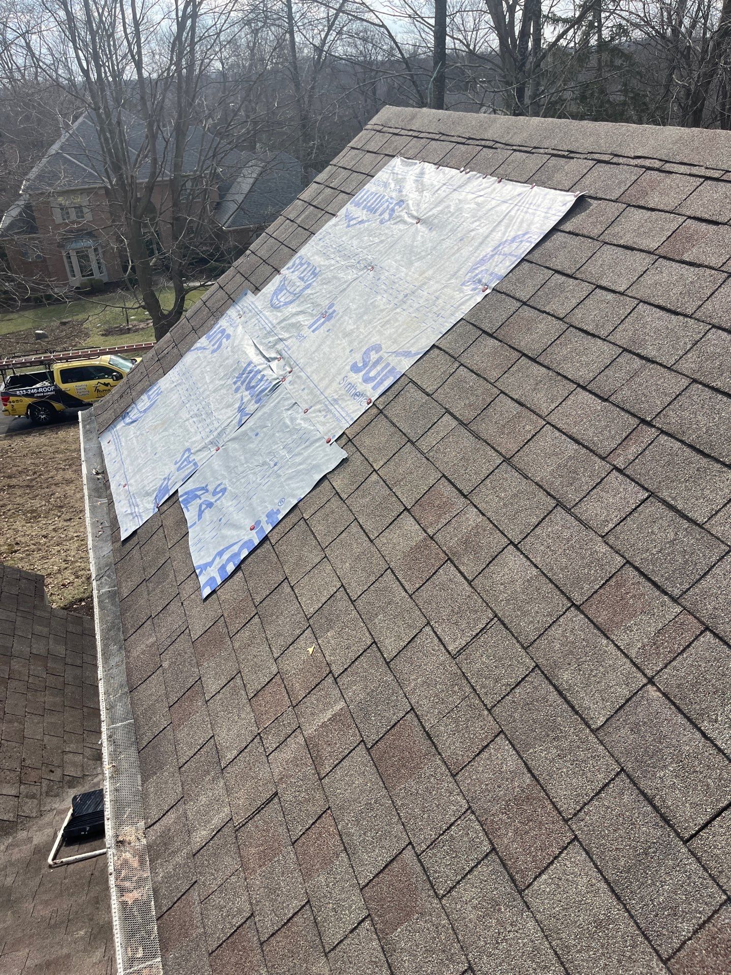Emergency tarp secured over a storm-damaged roof section in Dayton, Ohio