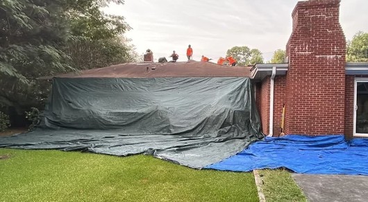 Tarps set up around home during roof replacement to protect landscaping and property in Dayton Ohio