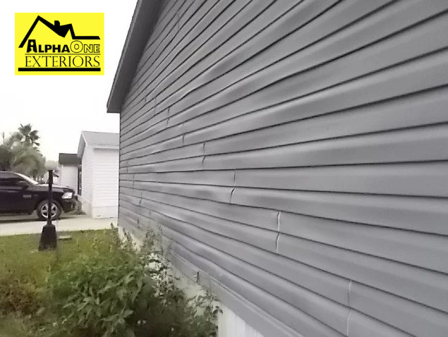 Buckled vinyl siding on a house in Dayton Ohio caused by heat, moisture, or improper installation.
