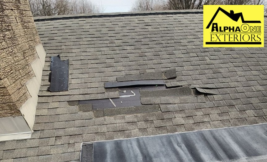 Roof damage in Xenia Ohio with shingles blown off and underlayment exposed due to high wind storm.
