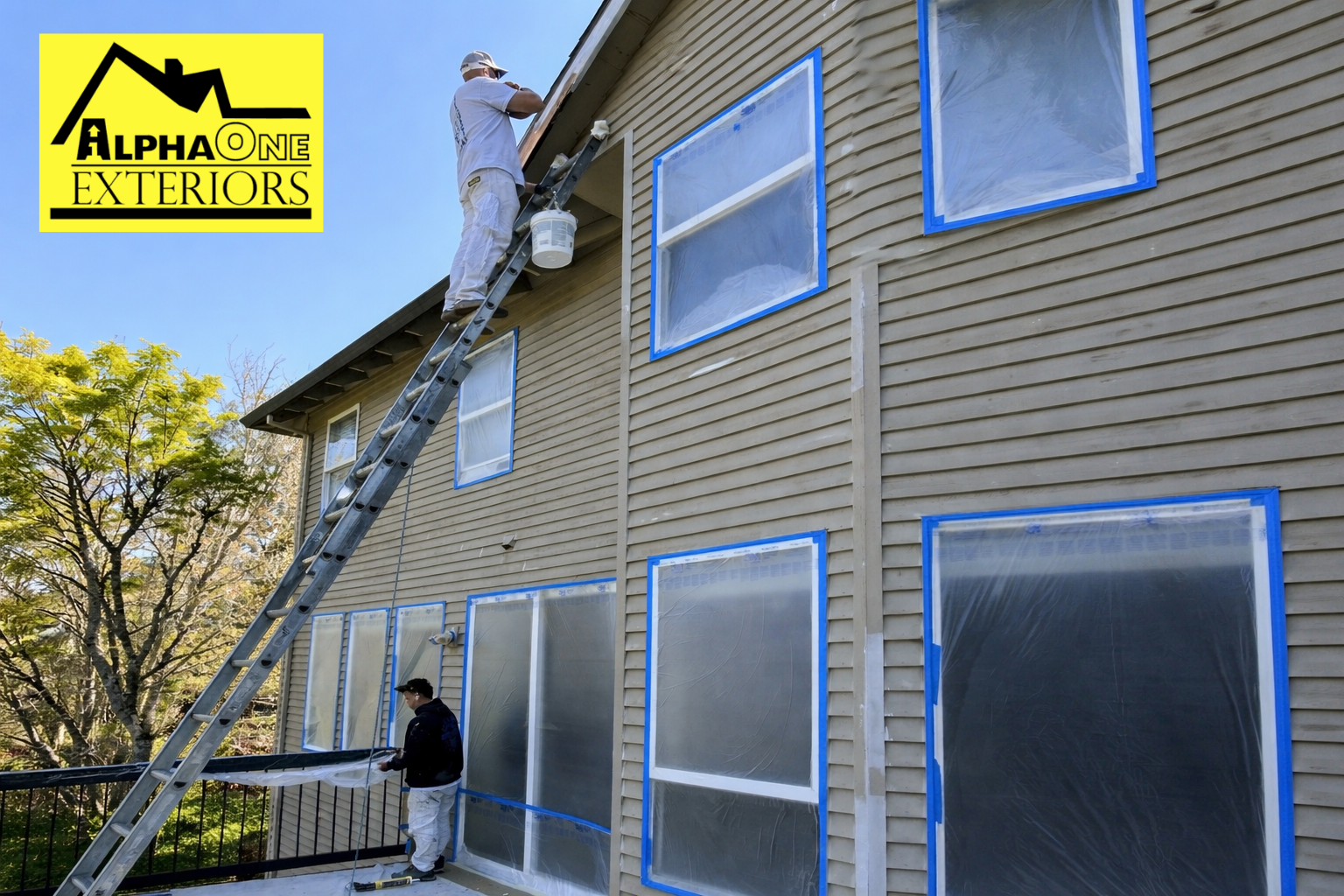 Painters working on residential exterior in Beavercreek Ohio with ladders and siding prep