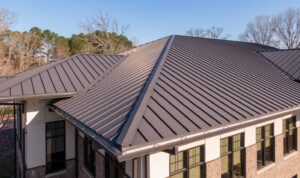 Residential standing seam metal roofing system in Dayton Ohio with dark bronze panels, ridge caps, and modern architectural design.