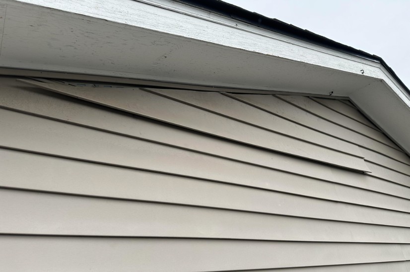 Loose vinyl siding in Dayton Ohio after high winds showing detached siding panels needing exterior repair