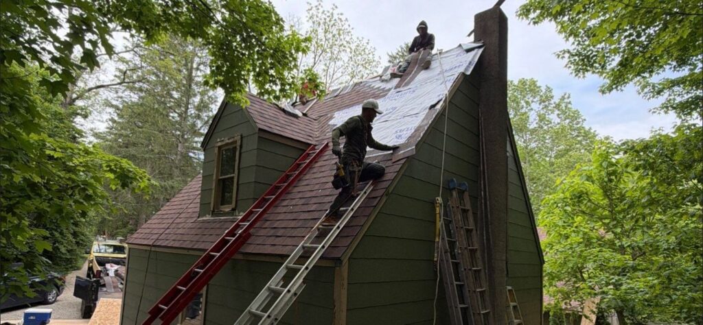 Steep roof replacement in Dayton Ohio with roofing crew installing architectural shingles and synthetic underlayment.