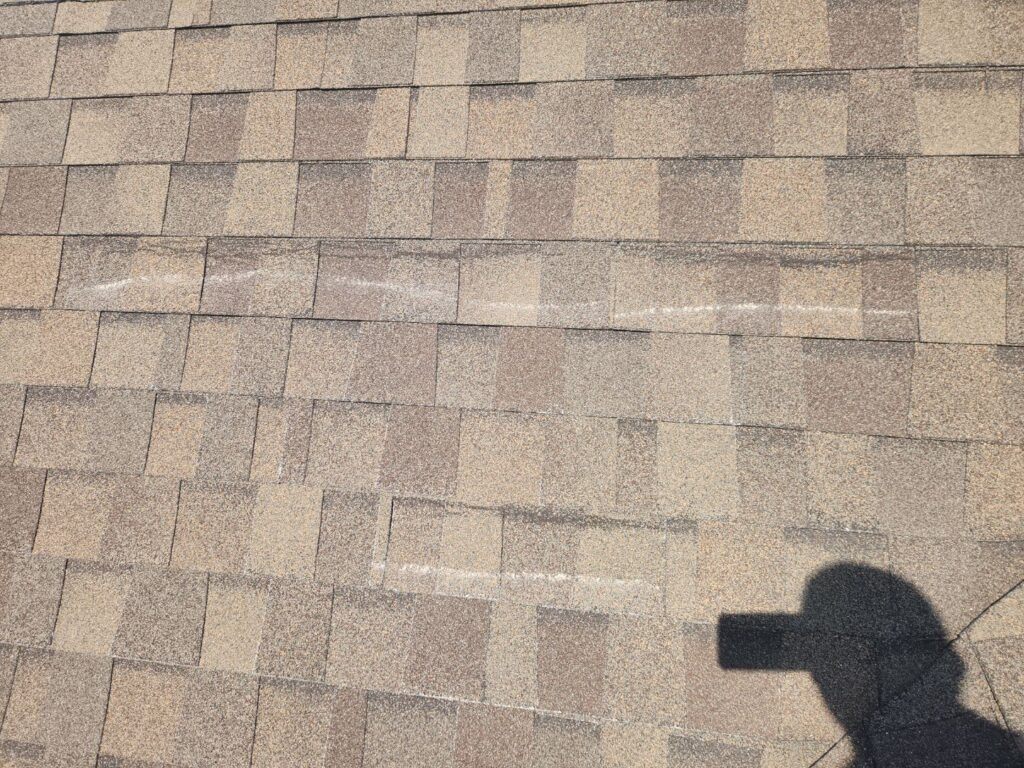 Wind-creased asphalt shingles identified during a roof inspection in Centerville, Ohio