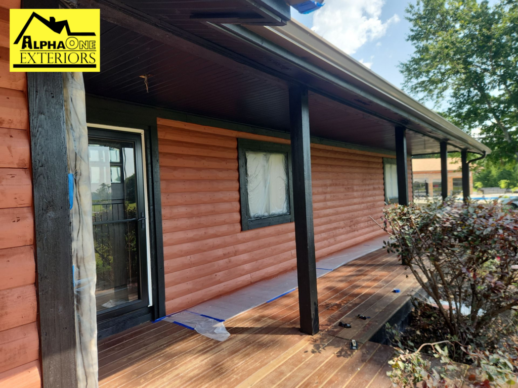 Exterior painting project showing reddish-brown horizontal siding with contrasting dark trim and porch columns.