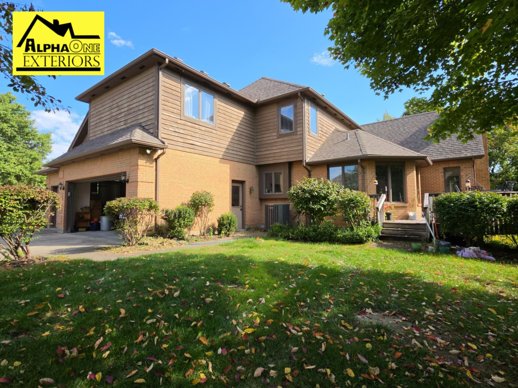 Two-story brick and siding home with gutters and downspouts installed along multiple rooflines to direct rainwater away from the house.
