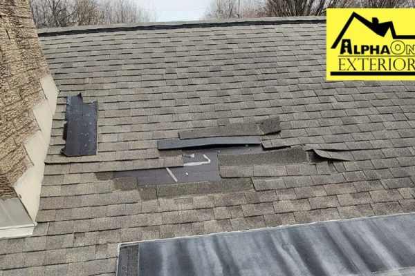 Roof damage in Xenia Ohio with shingles blown off and underlayment exposed due to high wind storm.